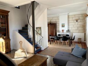 a living room with a staircase and a dining room at Maison de caractère avec jardin arboré en Avignon in Avignon