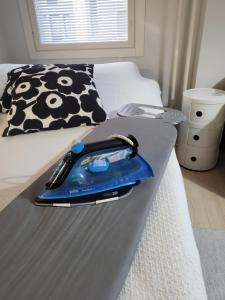a blue iron is sitting on a bed at Cozy studio in the city center in Rovaniemi