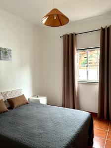 een slaapkamer met een bed en een raam bij Casa Mourato in Alpedriz