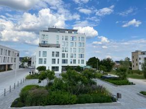 The Place Herzogenaurach - Serviced Apartments في هيرتسوجيناوراخ: مبنى أبيض مع شرفة فوقه