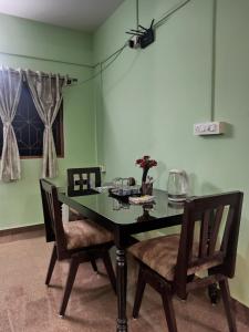 a dining room with a table and two chairs at Benirosa Home Stay Apartment 4 in Cansaulim