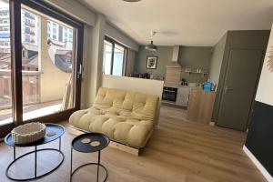 a living room with a couch and two tables and a kitchen at Destination Léman in Thonon-les-Bains