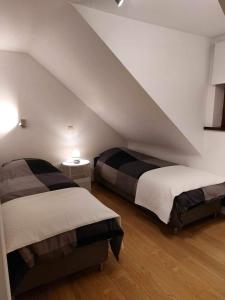 a bedroom with two beds in a attic at Gite L'Ecureuil - Appartement 4 personnes à Wépion (Namur) in Namur