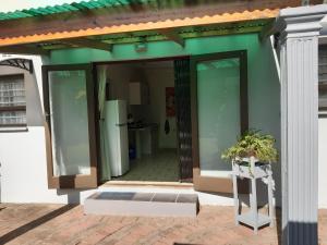 a house with glass doors and a porch with a refrigerator at Rosies in George