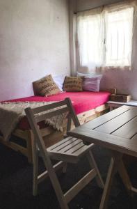 una camera da letto con un letto con materasso rosso e due sedie di Campo Verde III a Concordia