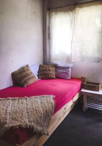 sypialnia z drewnianym łóżkiem z różową pościelą i poduszkami w obiekcie Campo Verde III w mieście Concordia