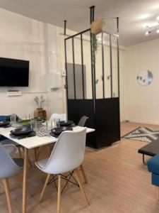 une salle à manger avec une table et des chaises blanches dans l'établissement Historic hyper-center Bourges, à Bourges