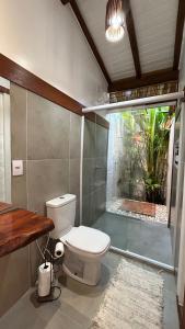 a bathroom with a toilet and a fish tank at Taipu Loft - Península de Maraú in Marau