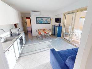 eine Küche und ein Wohnzimmer mit einem blauen Sofa in der Unterkunft Appartement Menton, 3 pièces, 5 personnes - FR-1-196-193 in Menton