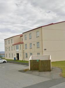 a large building in front of a parking lot at G-1215 apartment in Ytri-Njarðvík
