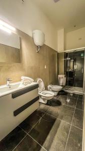 ein Badezimmer mit zwei WCs, einem Waschbecken und einem WC-istg in der Unterkunft B&B Ladislaus in Ladispoli