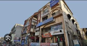 un grand bâtiment avec des panneaux sur son côté dans l'établissement HOTEL HARMONY, à Jamnagar