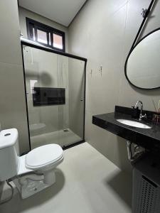 a bathroom with a toilet and a shower and a sink at Studios Mobiliados - Ambar Ipanema in Sinop