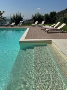 a swimming pool with a bunch of lounge chairs at Villa Le Torrette in Agropoli