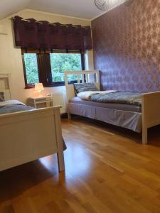 een slaapkamer met 2 bedden, een tafel en een raam bij Lyxvilla i Karlshamn in Karlshamn