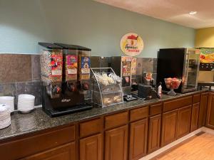 a counter in a restaurant with a counter top with food at Super 8 by Wyndham Monroe in Monroe