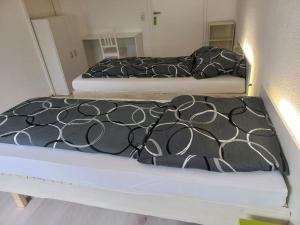 twee bedden met zwart-witte lakens in een kamer bij hoteliving Düsseldorf Airport in Ratingen