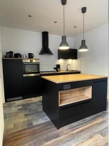 a kitchen with black cabinets and a wooden counter top at Ferienwohnung Seemöwe in Emden