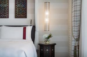 une chambre avec un lit et une table de chevet avec une lampe dans l'établissement Al Manara, a Luxury Collection Hotel, Aqaba, à Aqaba