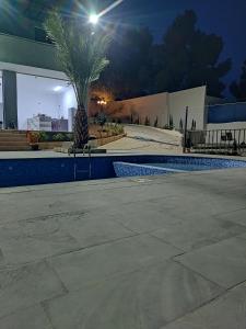 a swimming pool at night with a palm tree at شاليه 