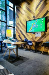 a room with a tv on a wall with a table and chairs at Wander Tokyo Shibuya in Tokyo