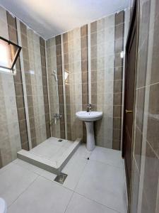 uma casa de banho com um lavatório, um chuveiro e um WC. em شاليه 