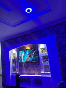 a room with a blue light on a brick wall at Cozy Home in Akure
