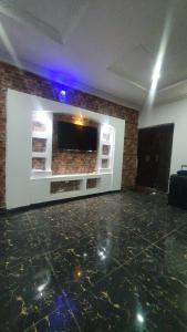 a room with a wall with a flat screen tv at Cozy Home in Akure