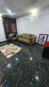 een woonkamer met 2 banken in een kamer bij Cozy Home in Akure