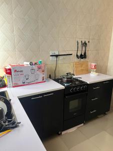 a kitchen with a stove and a box on the counter at Cozy Home in Akure
