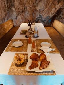 a table with bread and pastries on it at Villa Palmire, large terrace with jacuzzi available in La Turbie