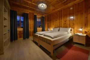 a bedroom with a bed in a room with wooden walls at Bait dal Colocator in Livigno