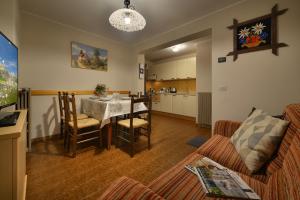 a living room with a table and a kitchen at Bait dal Colocator in Livigno