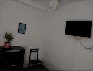 a room with a tv on a wall with a chair at Dpto Independiente Lanus Oeste in Gerli