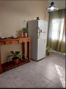 Il comprend une cuisine équipée d'un réfrigérateur et d'une table avec des plantes en pot. dans l'établissement Dpto Independiente Lanus Oeste, à Gerli