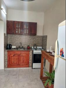 - une cuisine avec des placards en bois et une cuisinière dans l'établissement Dpto Independiente Lanus Oeste, à Gerli