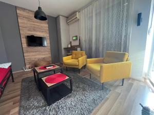 uma sala de estar com duas cadeiras amarelas e uma mesa em Bubinga em Kruševac