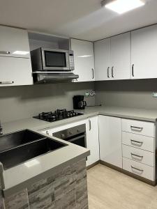 a kitchen with a sink and a microwave at Hermoso apartamento ubicado en uno de los mejores sectores de la ciudad in Cali