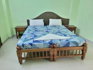 Una cama con un edredón azul y blanco. en Sea Star Beach Resort Kovalam, en Kovalam