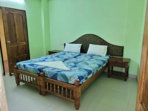 a bed with a blue and white comforter in a room at Sea Star Beach Resort Kovalam in Kovalam +16 photos