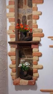kamienna ściana z dwoma wazami z kwiatami w obiekcie Un Tuffo nel passato "B&B Santu Giuvanni" w mieście Fonni