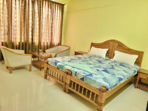 1 dormitorio con cama de madera y silla en Sea Star Beach Resort Kovalam, en Kovalam