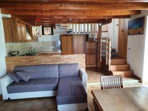 a living room with a couch and a kitchen at AL CASTAGNO in Ponte Caffaro