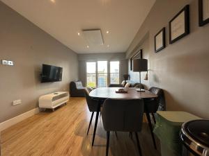 ein Wohnzimmer mit einem Tisch, Stühlen und einem Sofa in der Unterkunft The Cardiff Apartment in Cardiff