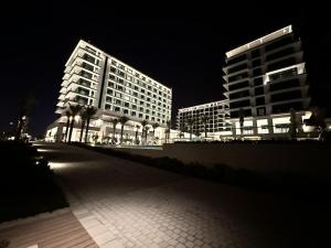 two tall buildings are lit up at night at Address Beach Resort Residence in Manama