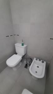 Un baño blanco con inodoro y lavabo. en Apartamento Brisas del Mar, en Santa Clara del Mar 10 fotos más