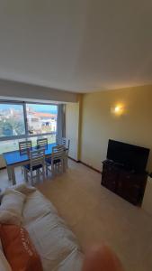 Una sala de estar con una mesa y sillas y un televisor. en Apartamento Brisas del Mar, en Santa Clara del Mar