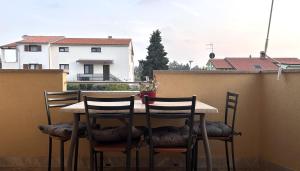 un tavolo e 4 sedie su un balcone di Apartments Marija a Novigrad Istria