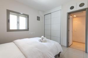 Biała sypialnia z łóżkiem z dwoma misiami w obiekcie O&O Group - Luxury Tower/parking/Shopping Mall/2BR w mieście Qiryat Ono