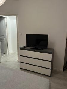 a tv sitting on top of a dresser in a room at Gîte Laurymoor - Normandie in Acquigny
